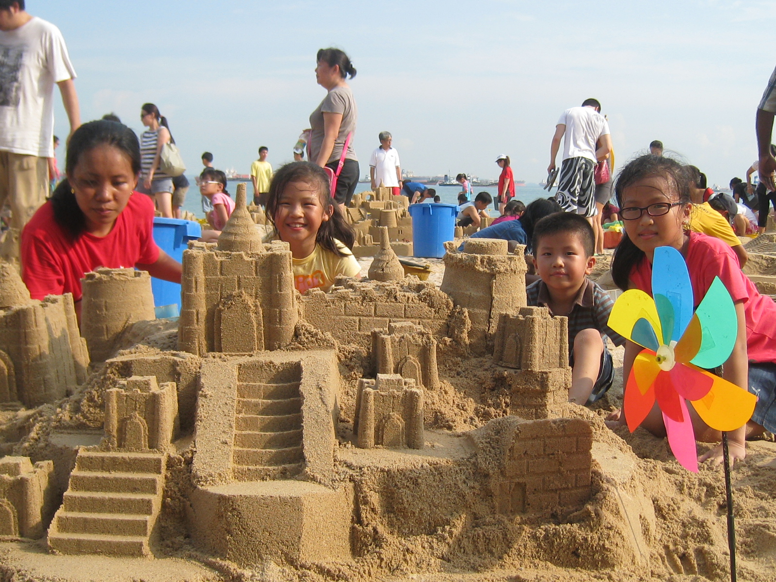 Make a sand castle. Песочный замок. Дети строят песочный замок. Песочный замок в песочнице. Строить песочные замки семья.